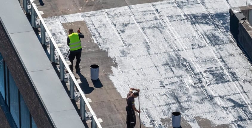 Commercial Roofing Systems November Blog 1 Professionals applying coating to a commercial roof