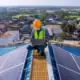 Asian Technician Checks The Maintenance Of The Solar Panels On The Roof