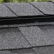Residential sloped roofing systems can include a roof ridge vent