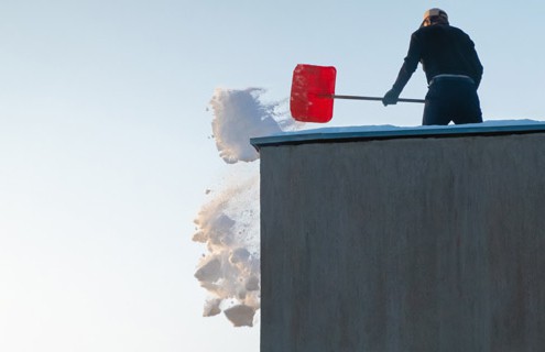 Low slope roof winter protection includes accumulated snow removal